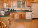 Kitchen. Window faces south. Includes stove, refrigerator, microwave, dishwasher, cookware, dishes, other small appliances.