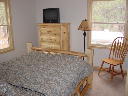 Main floor bedroom. Windows face north and west.  Includes queen bed, chest of drawers, nightstand, am/fm clock radio, phone, large closet.