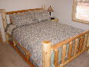 Main floor bedroom. Includes queen bed, chest of drawers, nightstand, am/fm clock radio, phone, large closet.