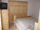 Second floor bedroom. Window faces south.  Includes queen bed, chest of drawers, nightstand, am/fm clock radio, phone, large closet.
