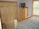 Second floor master bedroom. Window faces north. Includes queen bed, chest of drawers, nightstand, am/fm clock radio, phone, large closet. 